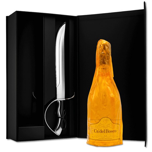 Scatola regalo in elegante cartone satinato nero con chiusura calamitata con sciabola pesante in metallo e impugnatura in elegante legno di colore nero, attrezzatura per effettuare il sabrage, ovvero apertura dello champagne o spumante effettuata facendo saltare il collo in vetro della bottiglia. cm 43.6x22.3x10

Una Bottiglia di Cà del Bosco Franciacorta da 75 cl inclusa